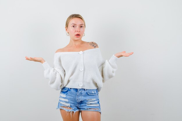 Foto gratuita giovane donna bionda con un maglione bianco