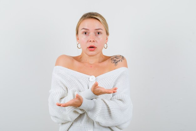 Young blonde woman in a white sweater