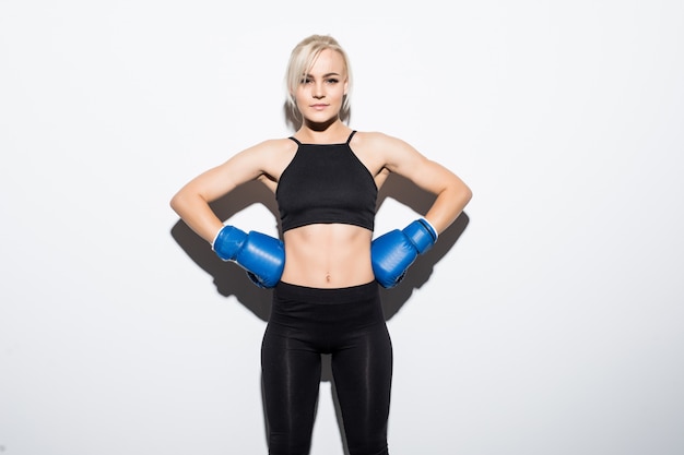 Young blonde woman with blue boxing gloves prepared to win on white