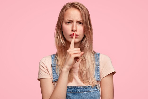 Young blonde woman with denim overalls