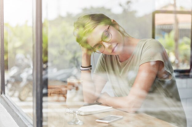 カフェでメガネの若いブロンドの女性