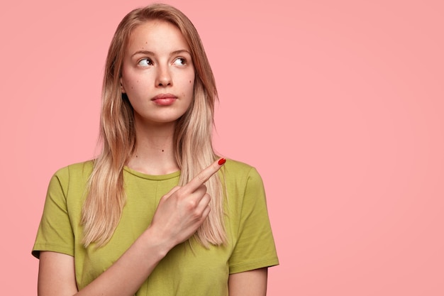 緑のtシャツを持つ若いブロンドの女性