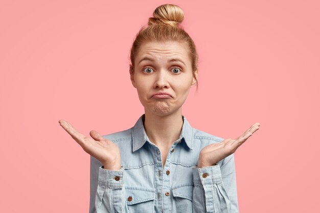 Young blonde woman with hair in bun and wearing denim jacket