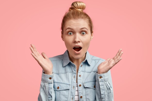 Young blonde woman with hair in bun and wearing denim jacket