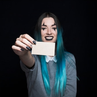 Young blue haired woman posing with paper card