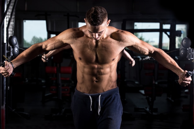 Free photo young bodybuilder using fitness equipment