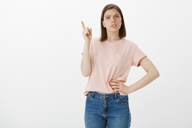 Young bossy woman scolding someone, shaking finger and teaching lesson