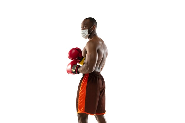 Young boxer in protective mask and boxing gloves