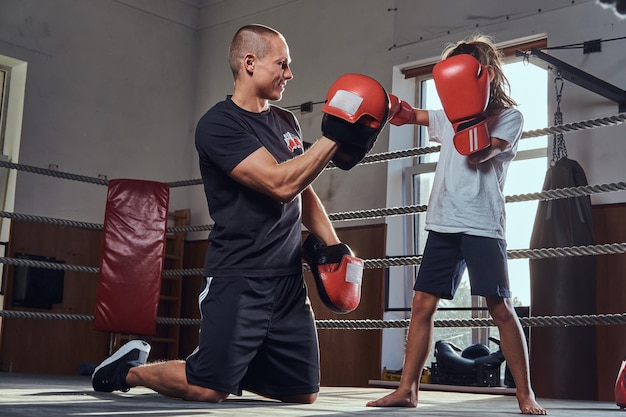 Free photo young boxer trainer is training new girl boxer for special competitions.