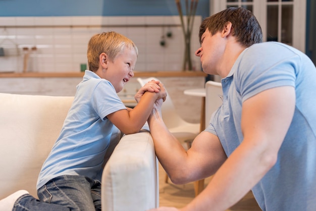 Young boy arm wrestling with his father