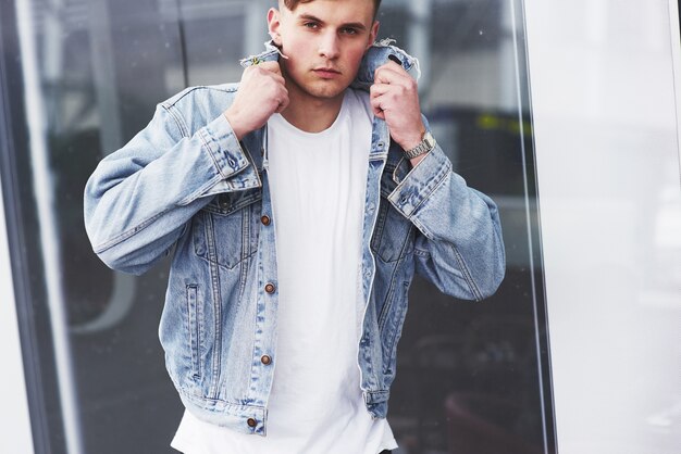 Young boy in a blue denim jacket on the street.