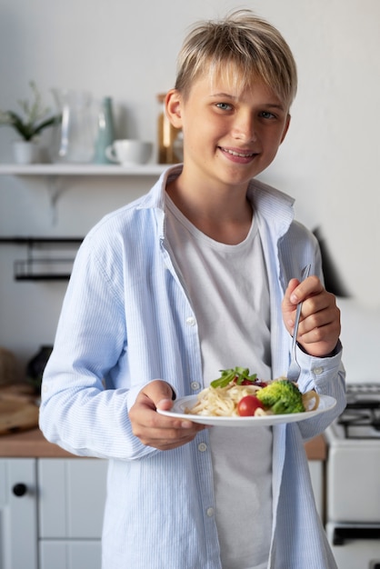 Free photo young boy eating healthy food