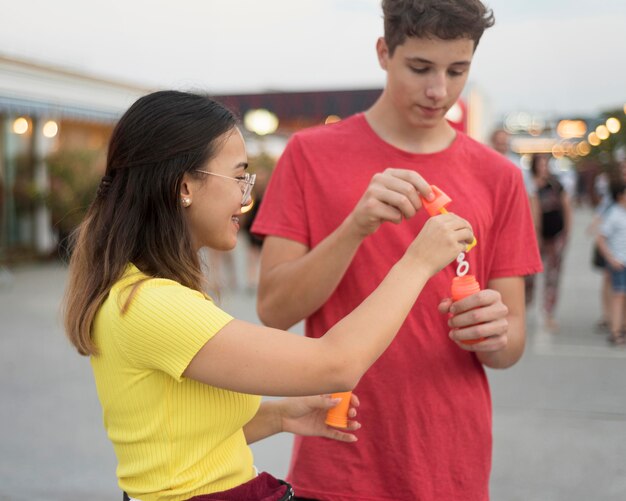 Young boy and girl blowing bubbles together