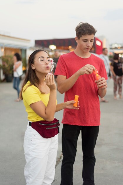 Young boy and girl blowing bubbles together