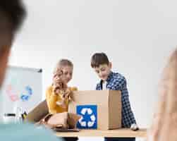 Free photo young boy and girl learning how to recycle