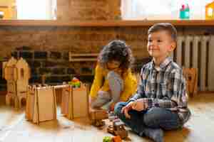 Free photo young boy and girl playing indoors with eco toys