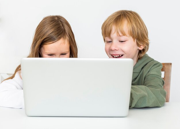 Young boy and girl using laptop