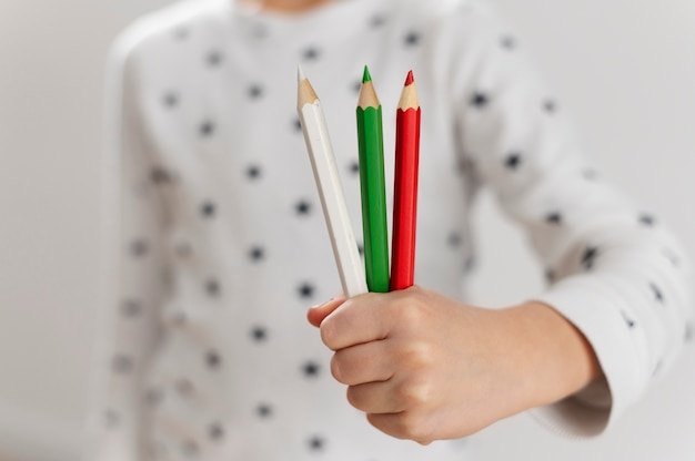 Free photo young boy holding pencils with the colors of the bulgarian flag