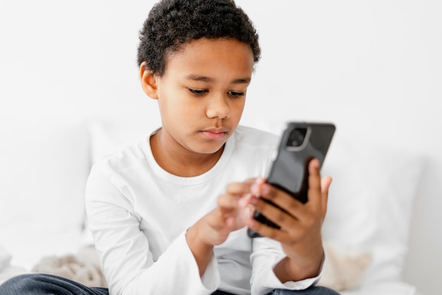 Молодой мальчик ребенок с помощью мобильного телефона