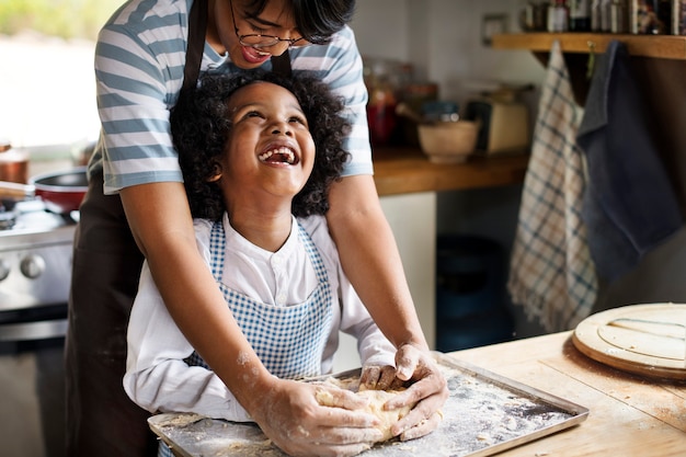 Free photo young boy learning to bake with his mother