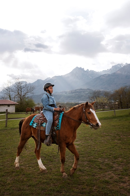 Free photo young boy learning how to ride horse