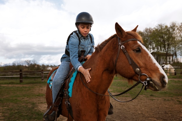 Young boy learning how to ride horse
