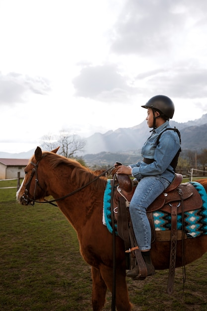 Foto gratuita giovane ragazzo che impara a cavalcare