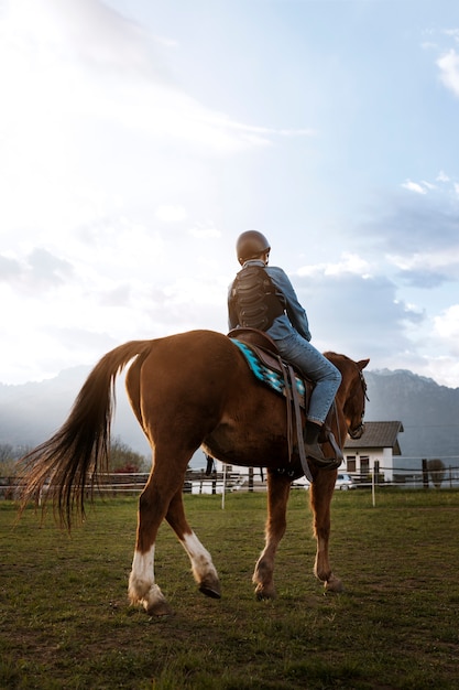 Young boy learning how to ride horse