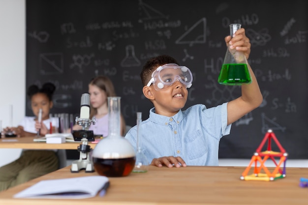 Free photo young boy learning more about chemistry in class