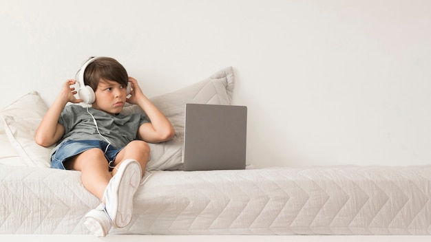 Free photo young boy looking on laptop