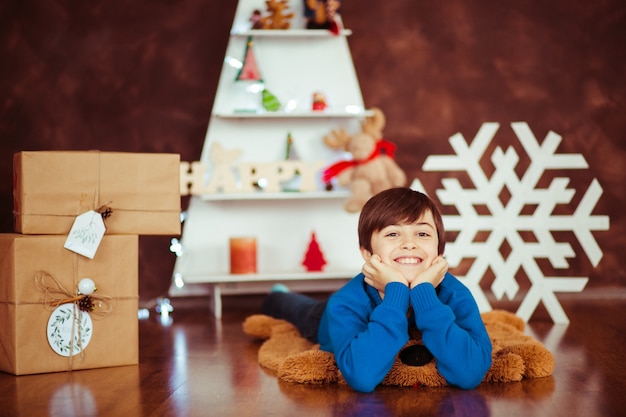 "Young boy lying on floor smiling"