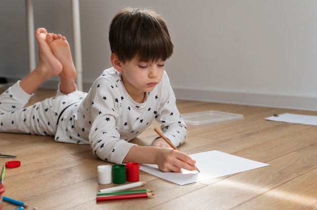 自宅でブルガリアの国旗を描く少年