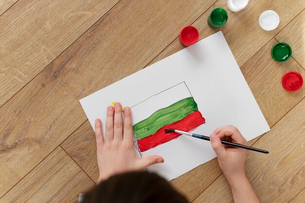自宅でブルガリアの国旗を描く少年
