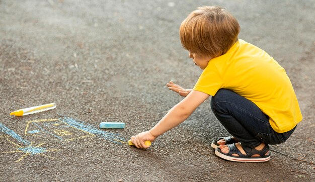 Young boy in park drawing