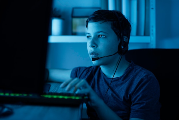 Free photo young boy playing on computer