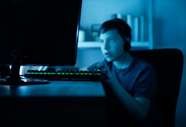 Free photo young boy playing on computer