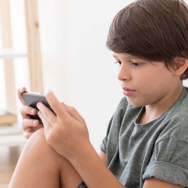 Young boy playing on smartphone