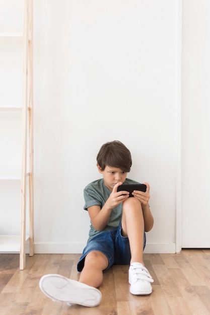 Young boy playing on smartphone