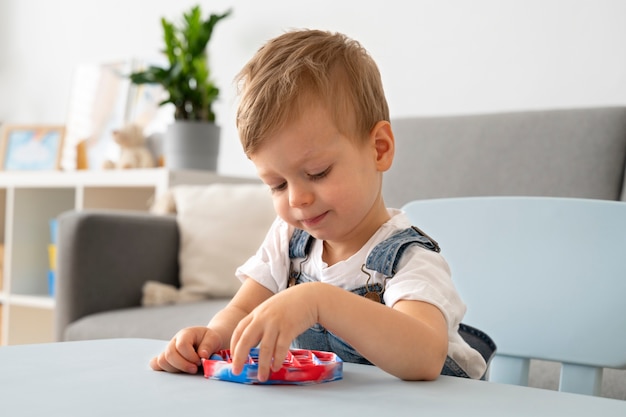 Free photo young boy playing with fidget at home