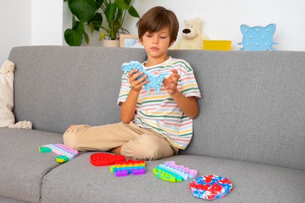 Free photo young boy playing with fidget toy at home