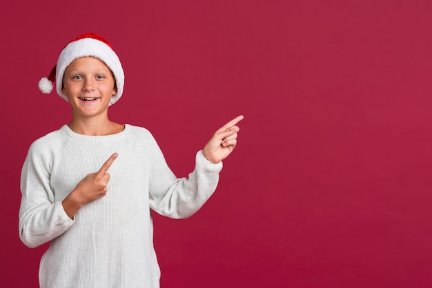 Free photo young boy pointing at copy space