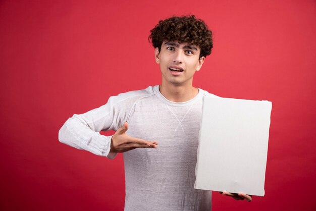 Young boy pointing at empty canvas  .