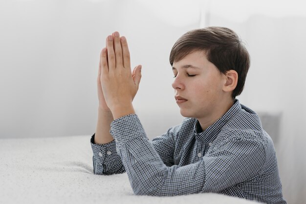 家で平和に祈る少年