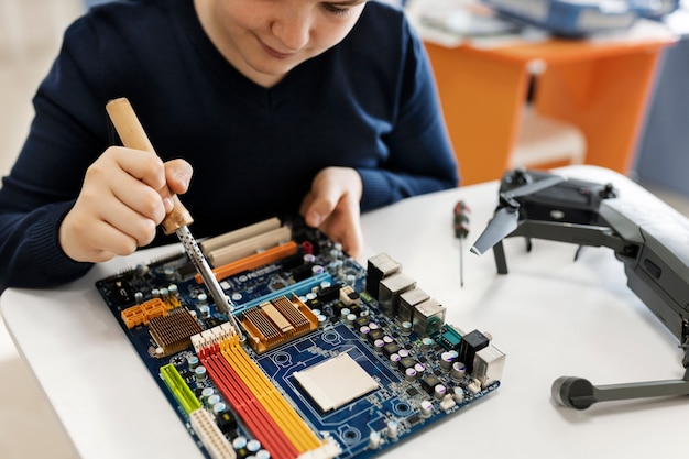 Young boy repairing an electronic component