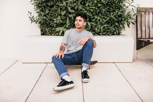 Young boy sitting on skateboard