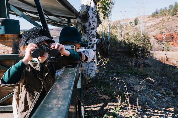 Foto gratuita giovane ragazzo in piedi con il binocolo