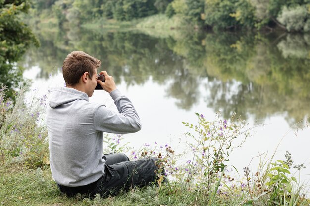 Молодой мальчик фотографировать возле озера