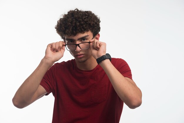 Young boy with curly hairstyle wearing eyeglasses. 