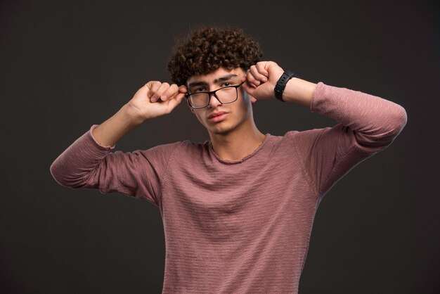 Young boy with curly hairstyle wearing eyeglasses. 