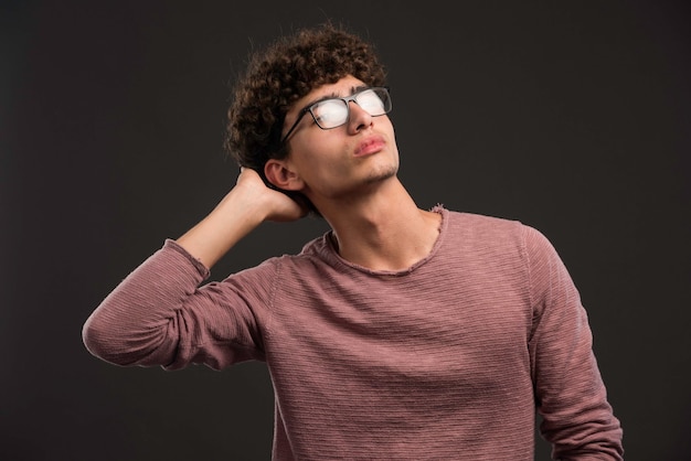 Young boy with curly hairstyle wearing eyeglasses. 